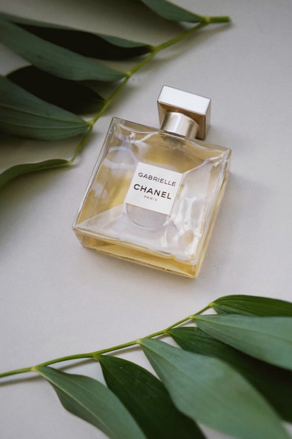 Product image (a perfume bottle accompanied with some leaves).